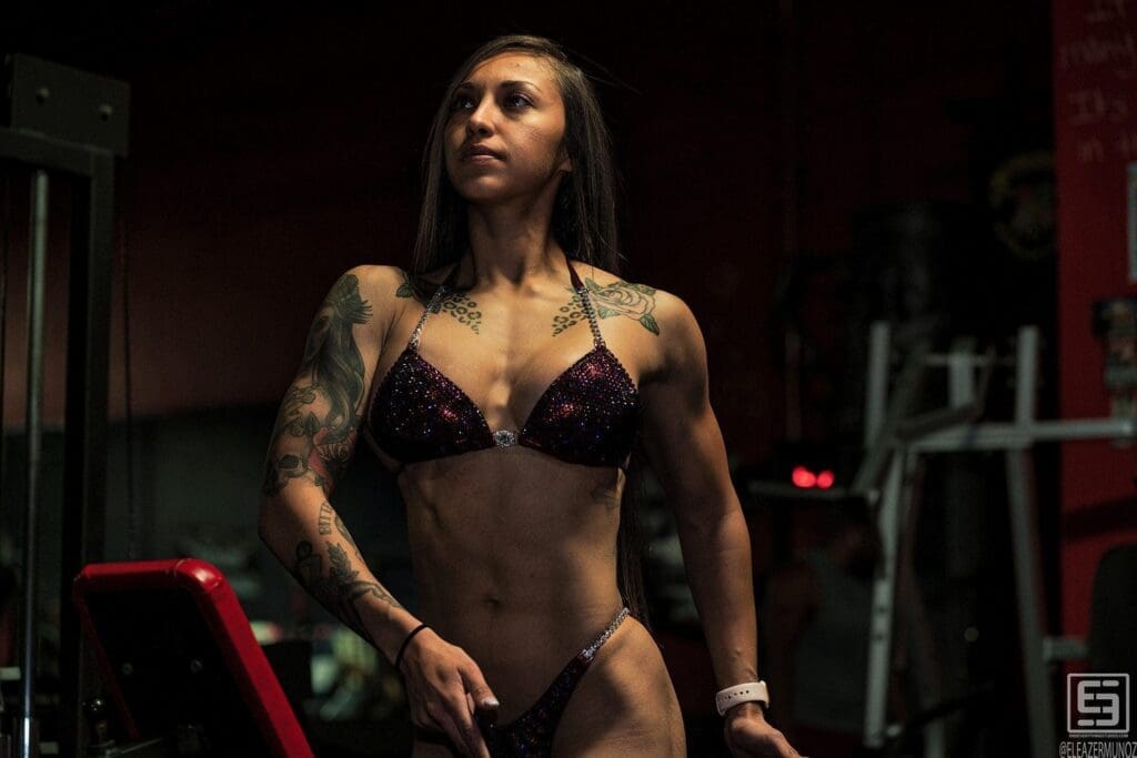 Danni looks upward in a three-quarter portrait wearing a dark sparkling posing suit.
