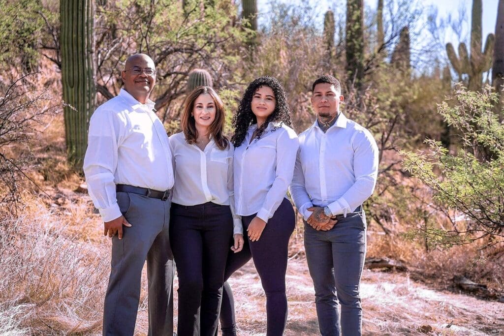 Four family members stand together among desert trees and saguaros.