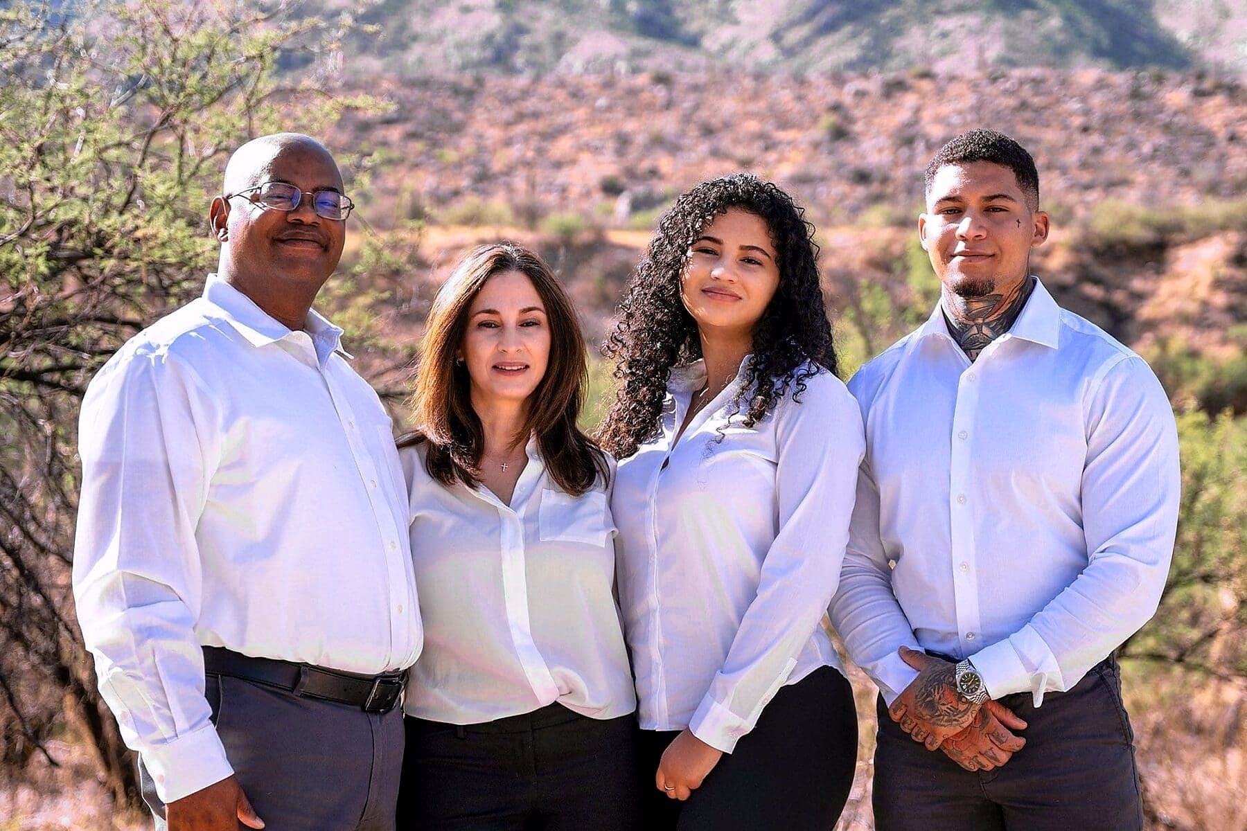 A closer view shows four family members posing together with a rocky hillside behind them.