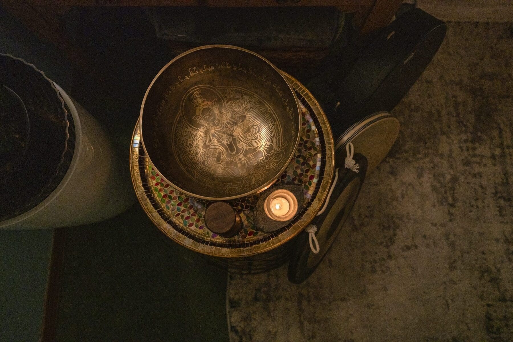 An overhead detail of bowls, bells, and metal sound-therapy instruments arranged indoors.
