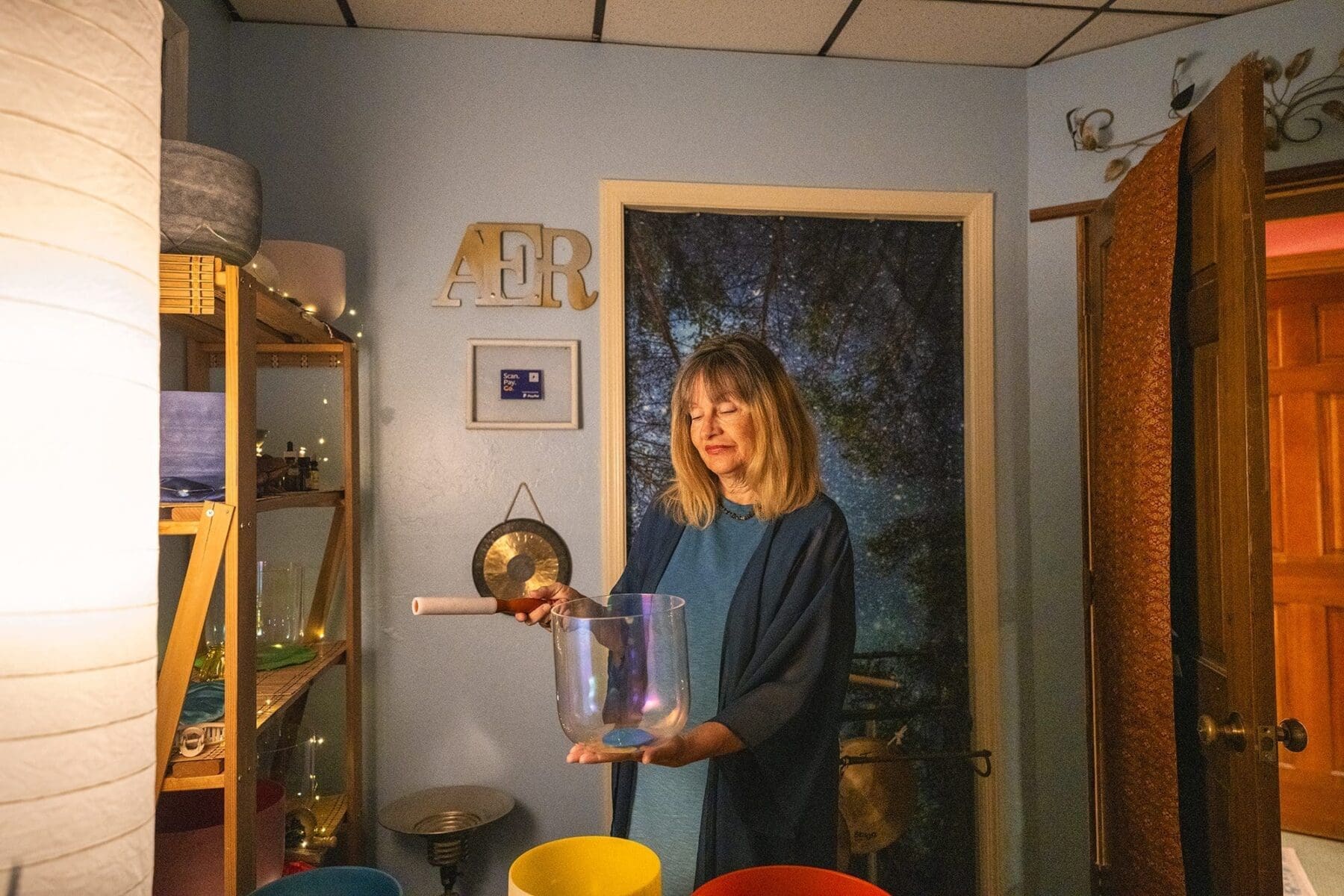 Kat Styrcula demonstrates a purple crystal bowl during the sound-therapy session.