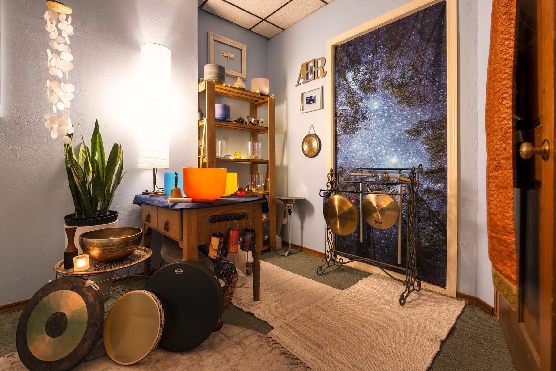 A wide view of Kat Styrcula’s instrument room with crystal bowls, gongs, and meditation tools.
