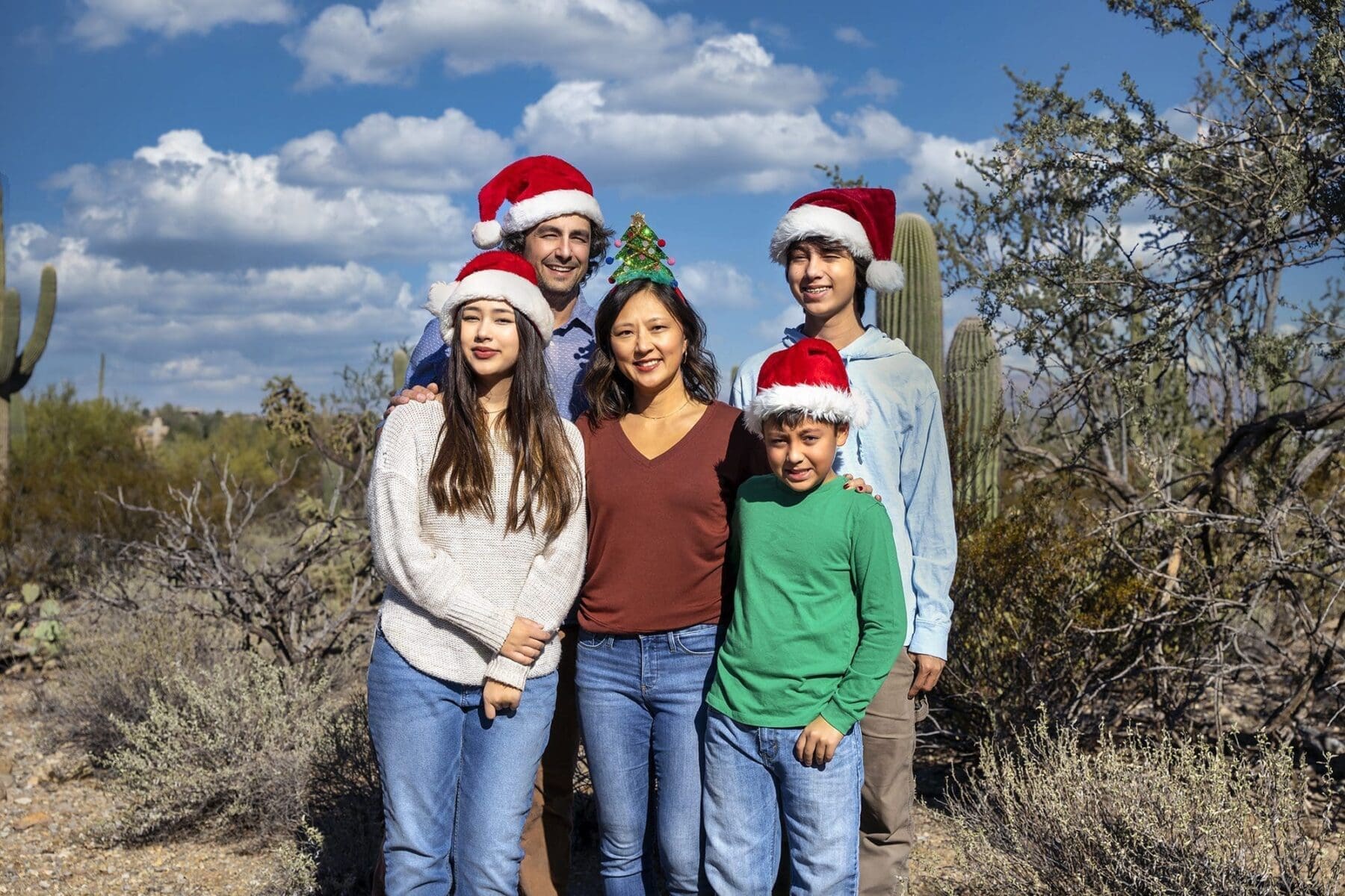 Five members of the Simpkins family wear Santa hats for a holiday portrait in the desert.