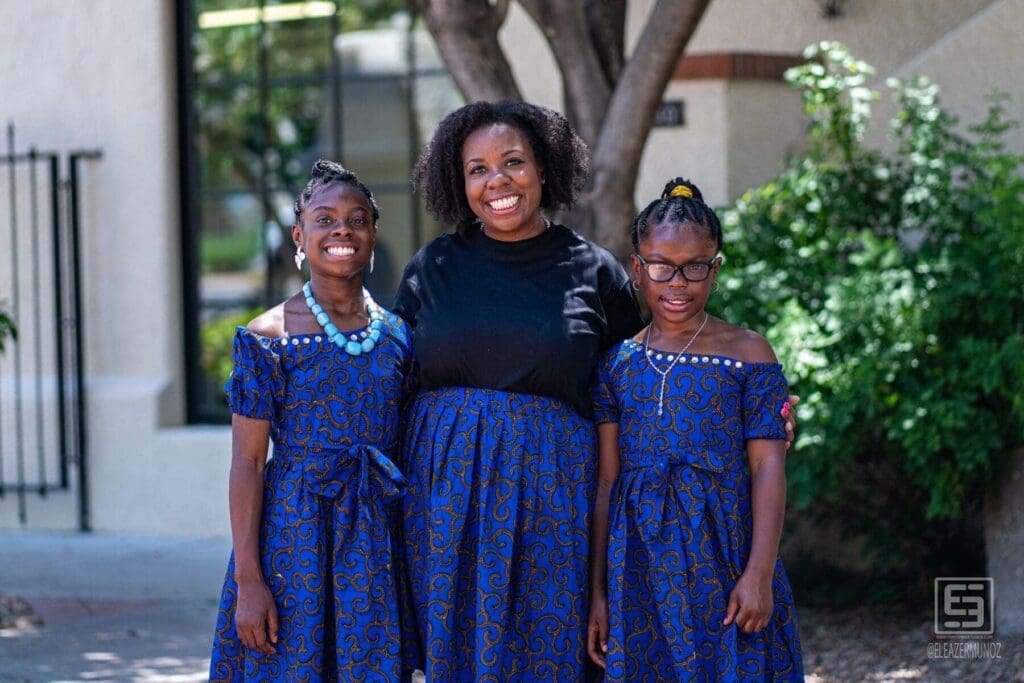 Three young women pose together in coordinated blue patterned clothing.